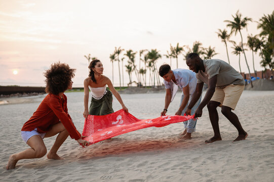 Friends enjoying a fun travel adventure on a tropical beach at sunset, making lasting memories