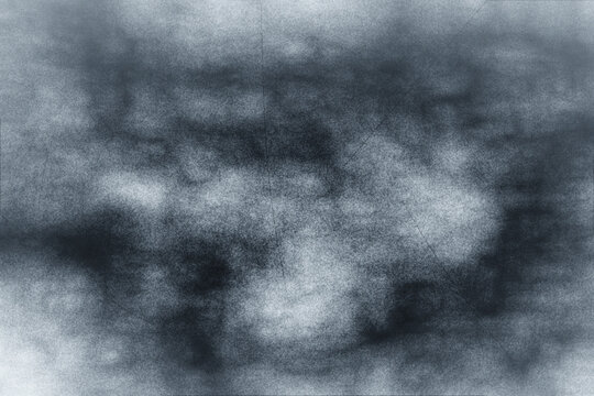 Abstract dark gray and white background with a smoky, grainy texture, excellent for mysterious and atmospheric grunge designs.