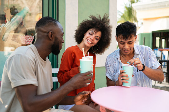 Diverse group of happy young friends meeting on a tropical beach, celebrating friendship and unity