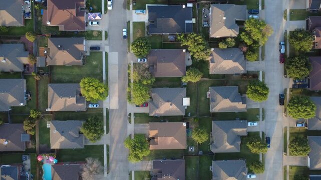 Parallel lot perimeters border quiet avenues within North Texas Lakewood Estates. Manicured sod yards, shingle rooftops, private fences portray orderly development, Little Elm, Texas