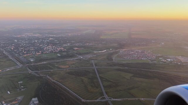 Aerial view from airplane over Saint Petersburg region during sunset. City outskirts fields and roads fading into evening light. Suitable for urban horizon concepts regional development travel visuals