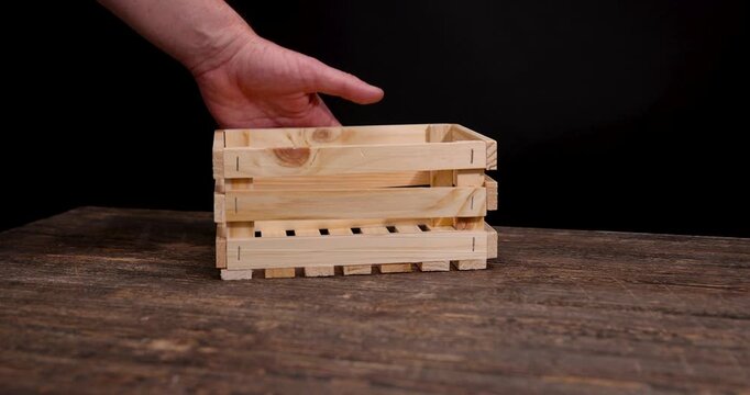 Empty light wooden box crate on dark background table, small natural pine timber box container standing on brown counter surface