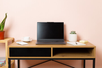 Fototapeta premium Comfortable workspace with laptop, notebook and flower