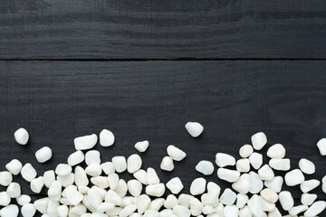 White pebble stones on wooden background, top view © Liami