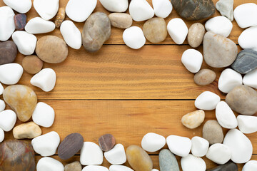 White pebble stones on wooden background, top view © Liami