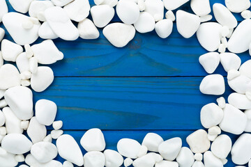 White pebble stones on wooden background, top view © Liami