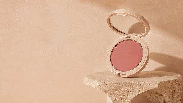 Pink blush ideas for natural makeup looks with soft powder compact on stone surface in warm minimal lighting