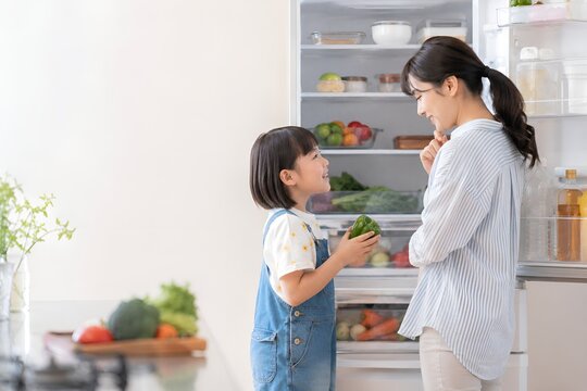 冷蔵庫の食材を確認しながら夕食の献立を考える日本人親子 食品ロス削減と節約を意識した暮らし（AI生成）