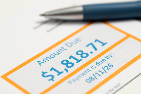 A utility bill displaying the amount due and payment deadline with a pen, illustrating household expenses, budgeting, medical bill payments, personal finance and financial planning.