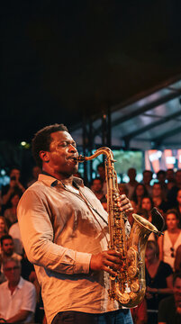 African american musician playing saxophone on music festival stage. Jazz performer entertaining live crowd during concert. Soulful instrumental hobby, artistic musical talent concept.