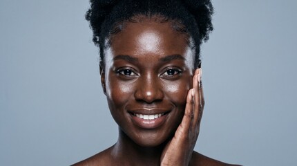 Obraz premium Portrait of a beautiful Black woman with glowing skin posing against a grey background