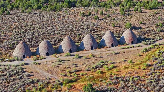 Aerial view of historic stone beehive kilns illuminated by golden sunrise light in Ward Charcoal Ovens State Historic Park Nevada