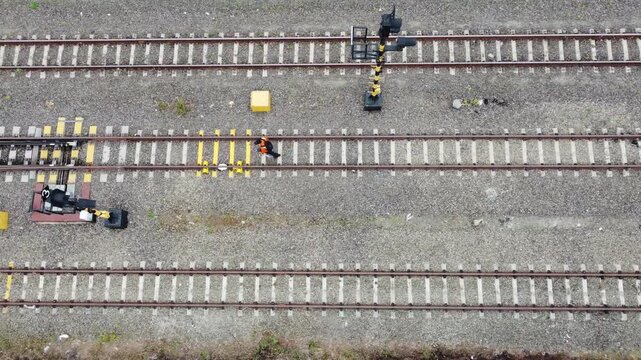 A railway worker inspects the safety of the raiway track. Drone view