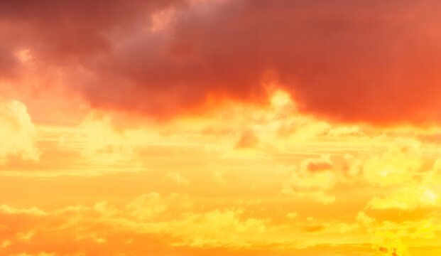Fiery orange and red clouds blaze across a dramatic sunset sky.