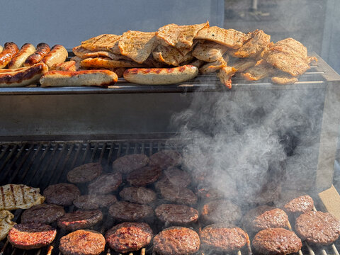 Grilled sausages steaks and burger patties on barbecue grill