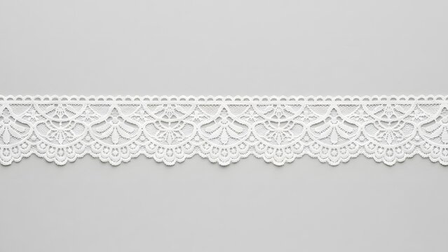 Delicate white lace trim with a floral pattern on a light gray background
