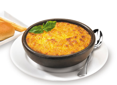 Traditional Chilean pastel de choclo baked sweet corn and beef pie served in a rustic clay bowl, isolated on a clean white background