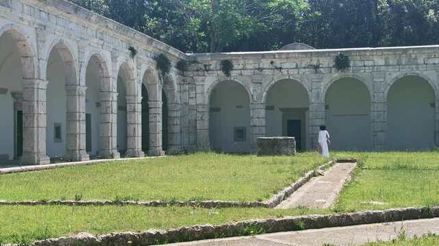 Woman walking through ancient museum garden on Capri Island Italy