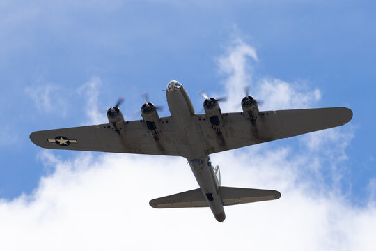 Close bottom view of a WWII bomber (B-17 Flying Fortress) against clouds