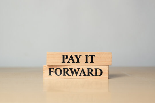 Wooden blocks with words Pay it forward. Business concept