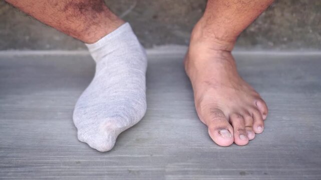 Person wearing ankle socks close up shot, hands adjusting fabric, morning dressing routine concept.