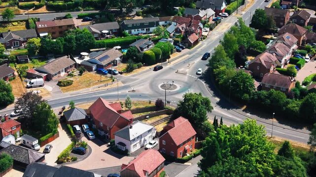 Drone shot over a suburban mini roundabout and residential streets on the edge of Romsey.