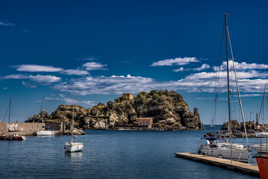 Sailboats and Isola Lachea in Aci Trezza Harbor