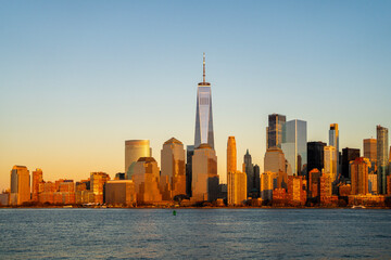 Fototapeta premium NYC Manhattan panorama city skyline. NYC Manhattan skyline glowing at dusk. NYC Manhattan skyline with downtown towers. NYC Manhattan skyline travel destination.