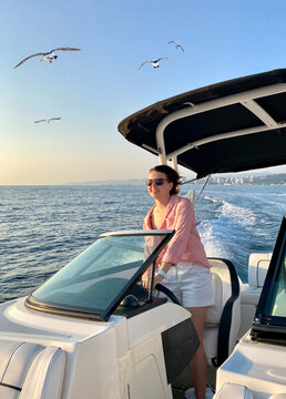 Woman behind the wheel yacht, enjoying sea nature, active sailor girl, female driving luxury water transport, summertime concept