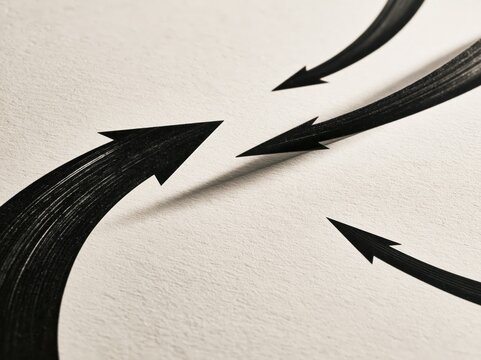 Black arrows converging together on textured paper