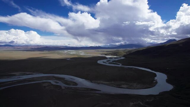 Drone view landscape along Chinese National highway G219, mountains and wetland river with blue sky and white clouds background in sunny day in Tibet, China, 4k real time footage b roll travel concept