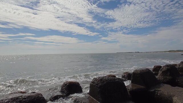Ocean waves and horizon viewed over concrete wave breakers