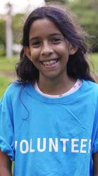 Teenage volunteer girl celebrating outdoors - Young Latin American woman supporting charity community project - Vertical video