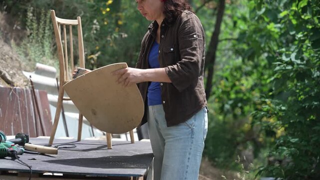 Woman Restoring an Old Chair: Sustainable Furniture Upcycling and Waste Reduction