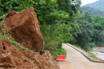 Fototapeta premium Tropical forest red soil landslide mountain road green vegetation rural landscape