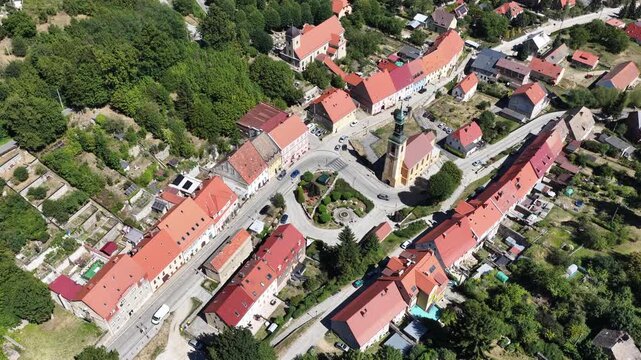 Aerial drone view of Srebrna Gora village in Lower Silesia, Poland, with historic Srebrna Gora Fortress, surrounding mountains and green landscape on a sunny summer day