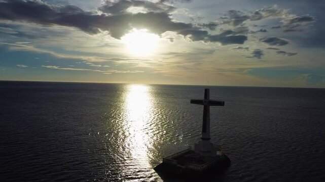Aerial view of the sunken cemetery cross at sunset in camiguin