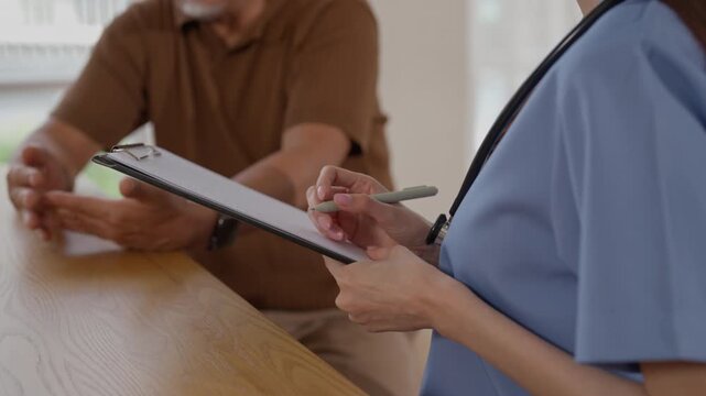 Senior patient consultation, healthcare professional and patient clinic discussion, medical form, attentive consultation, professional nurse writing clipboard during bright healthcare office visit