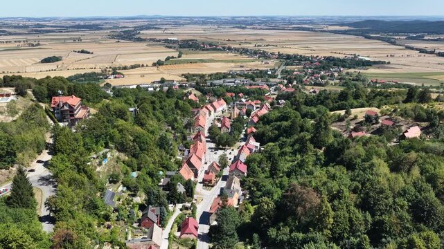 Aerial drone view of Srebrna Gora village in Lower Silesia, Poland, with historic Srebrna Gora Fortress, surrounding mountains and green landscape on a sunny summer day