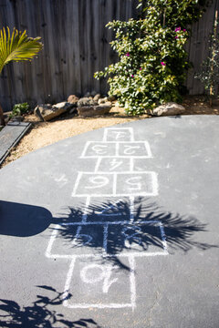 chalk hopscotch game drawn on concrete patio in australian backyard