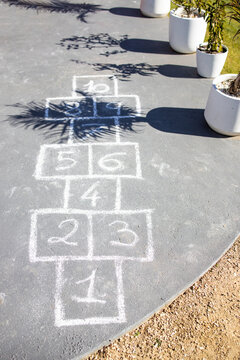 chalk hopscotch game drawn on concrete patio in australian backyard