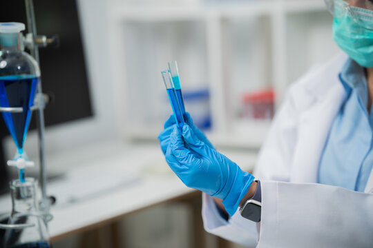 A female scientist is conducting chemical research in a laboratory, analyzing samples using test tubes and a microscope to drive advancements in biotechnology, medicine, microbiology, and healthcare.
