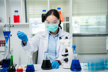 Fototapeta premium A female scientist is conducting chemical research in a laboratory, analyzing samples using test tubes and a microscope to drive advancements in biotechnology, medicine, microbiology, and healthcare.