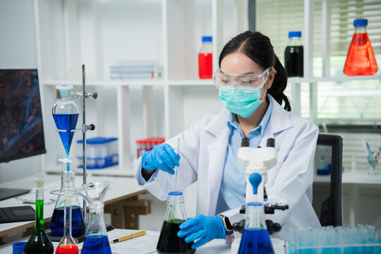 A female scientist is conducting chemical research in a laboratory, analyzing samples using test tubes and a microscope to drive advancements in biotechnology, medicine, microbiology, and healthcare.