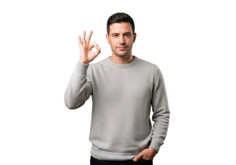 Naklejka premium Handsome man wearing a grey sweater showing an okay hand gesture to the camera isolated on white background