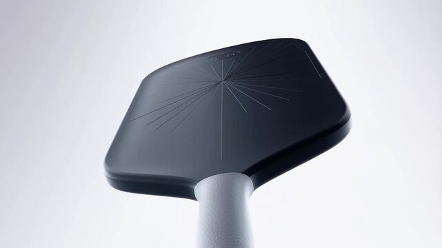 Professional pickleball paddle rotating slowly against a bright minimalist studio background