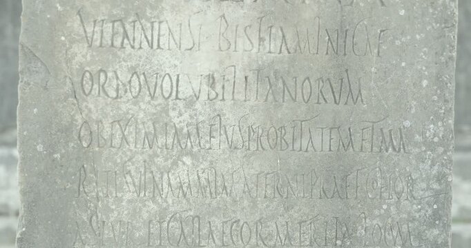 Close-up static view of a Latin inscription carved into stone at Volubilis, preserving Roman epigraphic evidence from Morocco's UNESCO World Heritage archaeological site.