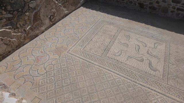 Slow cinematic moving view of a preserved Roman geometric mosaic floor at Volubilis, revealing intricate patterns and ancient craftsmanship at Morocco's UNESCO World Heritage site.