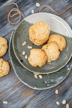 Peanut treat. Rustic snack. Crunchy sweets pile served on ceramic plate. Healthy traditional homemade cookies on dark table background.