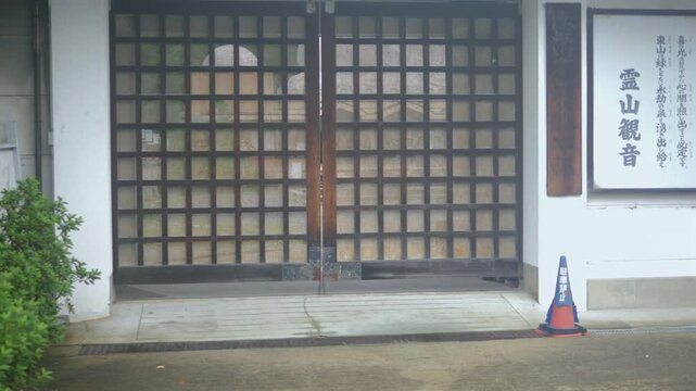Traditional wooden gate and Japanese sign at temple entrance in Kyoto, Japan